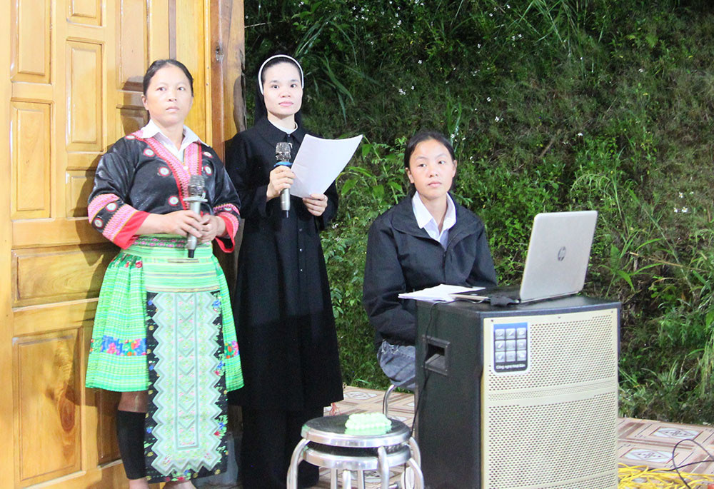 Lovers of the Holy Cross Sr. Mary Nguyen Thi Xuan (center) and Hmong Maria Sung Thi Senh (left) sing hymns for troupes to dance to at Sung Do Church in Vietnam on Oct. 7. The 40-year-old nun from Vinh Quang Convent, 20 kilometers away, teaches Hmong women how to arrange flowers, sing hymns, and dance. (GSR photo/Joachim Pham)