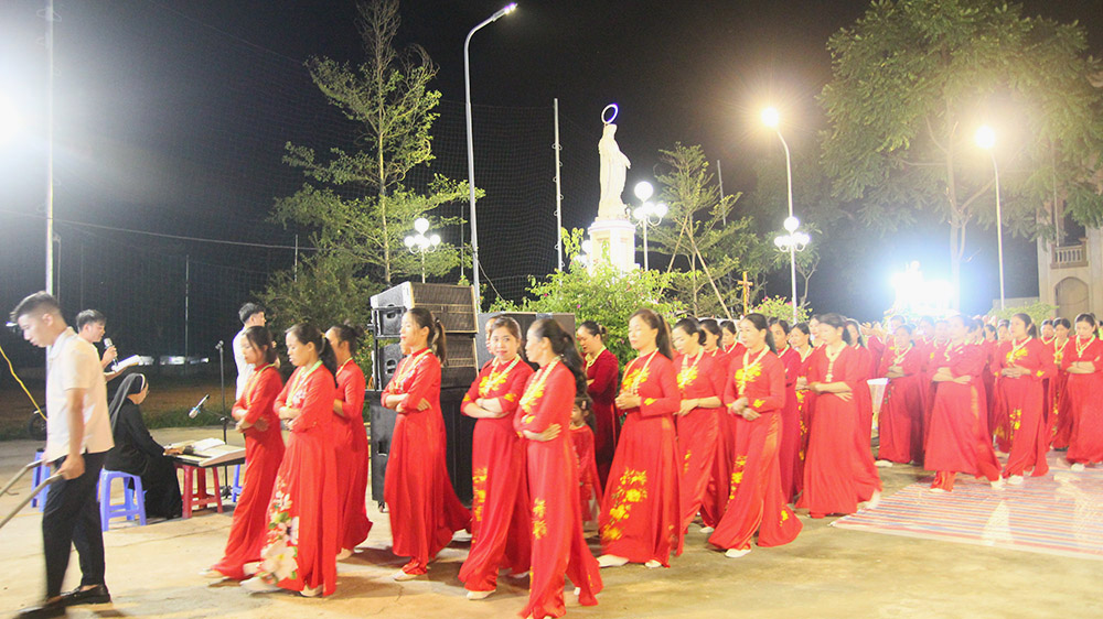 Seventy women in ao dai, or Vietnamese dress, march in a long ceremonial procession carrying a Marian statue around Vinh Quang Church in the Van Chan district, Vietnam, on Oct. 8. (GSR photo/Joachim Pham)