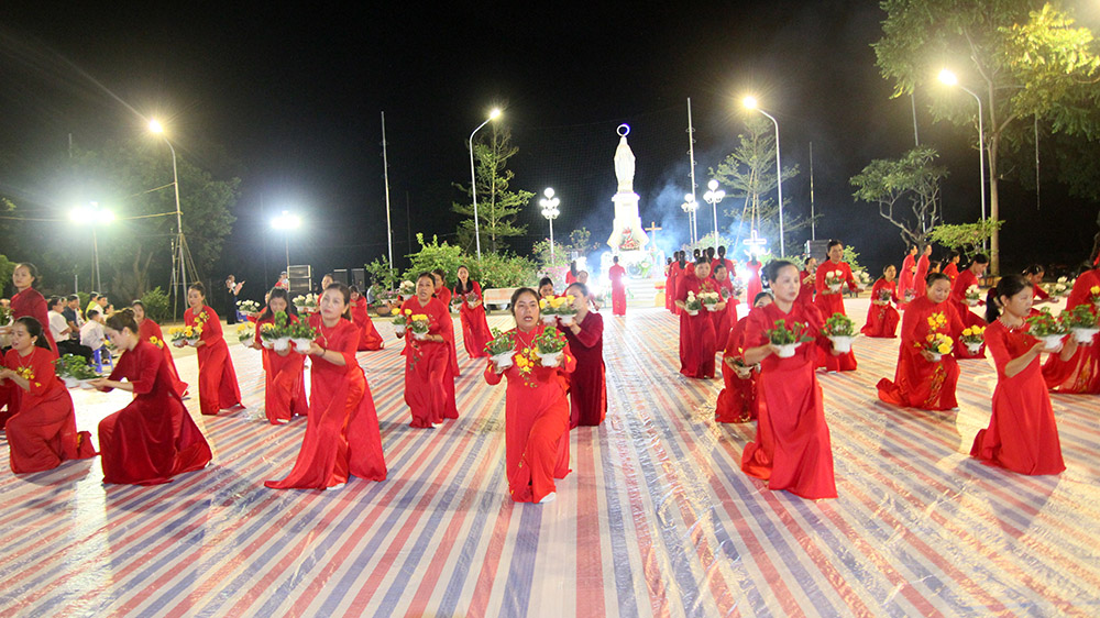 Dancers perform with flowers in front of a Marian statue at Vinh Quang Church in Vietnam's Van Chan district on Oct. 8. (GSR photo/Joachim Pham)