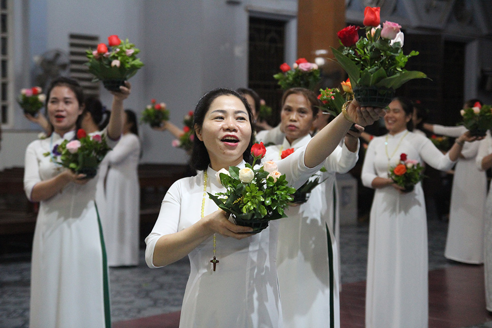 Mary Nguyen Thi Thu Huong (center) said three sisters were helping them to perform dang hoa on the evenings of Wednesdays and Saturdays in October at Yen Bai Church in the Diocese of Hung Hoa, Vietnam. "Dang hoa aims at encouraging local people to recite the rosary regularly and to pray for the evangelization work in the diocese," said the 35-year-old mother of two, who has joined the troupes for six years. (GSR photo/Joachim Pham)