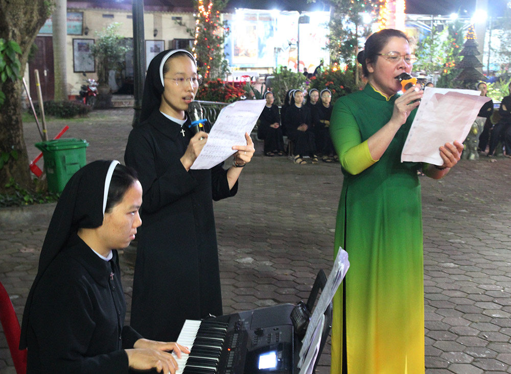 Sr. Mary Kieu Thi Anh Xuan plays the organ, and Sr. Mary Nguyen Thi Anh Tuyet (center) and Maria Pham Thi Thuy, a laywoman, sing hymns for dancers to perform in Yen Bai Church in Vietnam on Oct. 21. (GSR photo/Joachim Pham)