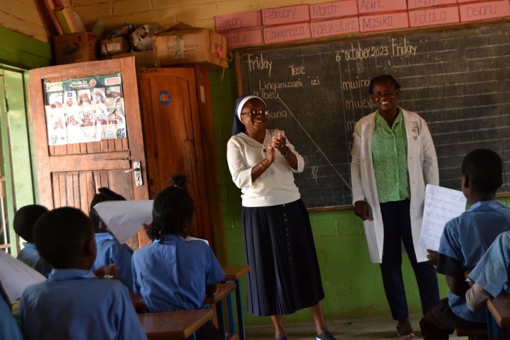 A nun and a teacher stand in front of a class. 