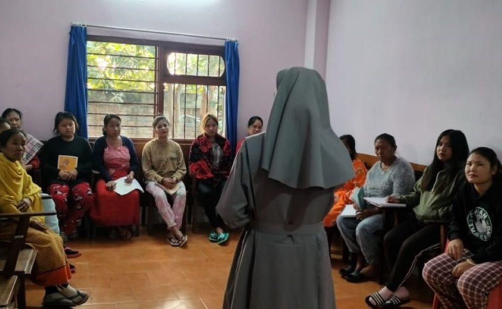 Nun, with back to camera, talks to a group of people.