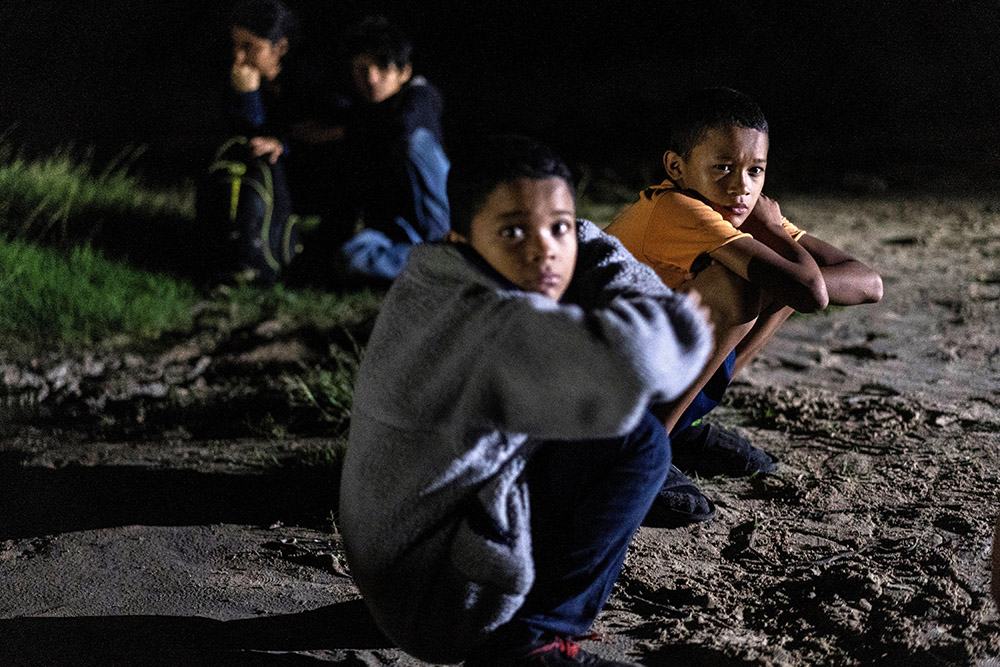 Unaccompanied minors who are migrants from Honduras sit on the riverbank in Roma, Texas, after crossing the Rio Grande July 9, 2021. (OSV News/Reuters/Go Nakamura)