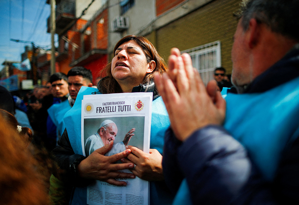 A woman prays while holding a newspaper with an image of Pope Francis during a Mass celebrated Sept. 5, to rebuff verbal attacks on the pontiff by presidential candidate Javier Milei, of La Libertad Avanza coalition, in Buenos Aires. (OSV News/Reuters/Agustin Marcarian)