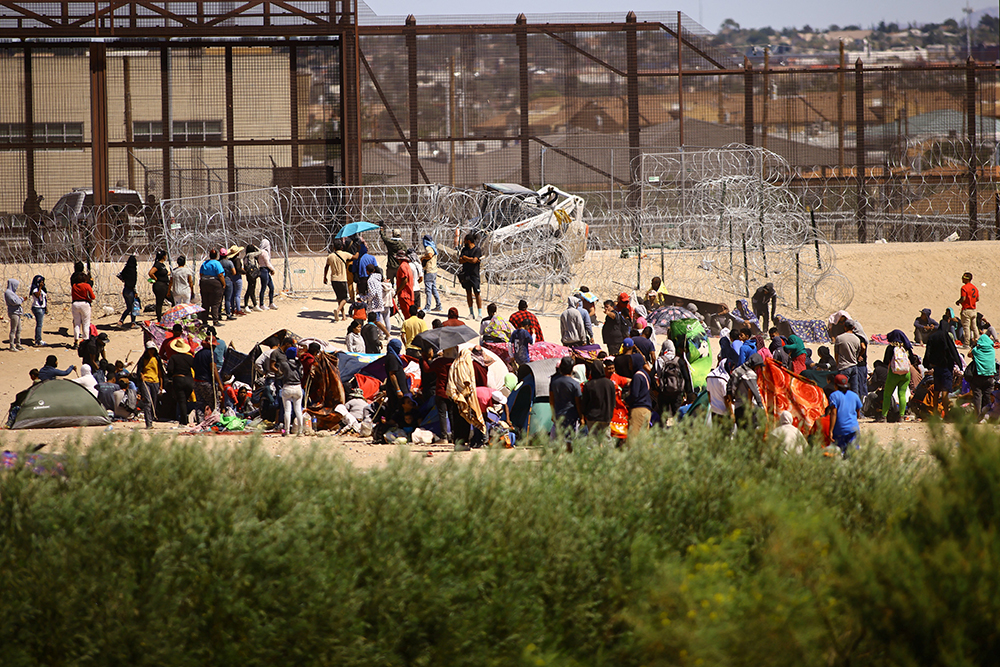 Migrants, mostly from Venezuela, are seen from Ciudad Juarez, Mexico, as they gather near the U.S. border wall Sept. 24 after crossing the Rio Grande with the intention of turning themselves in to U.S. Border Patrol agents to request asylum. (OSV News/Reuters/Jose Luis Gonzalez)