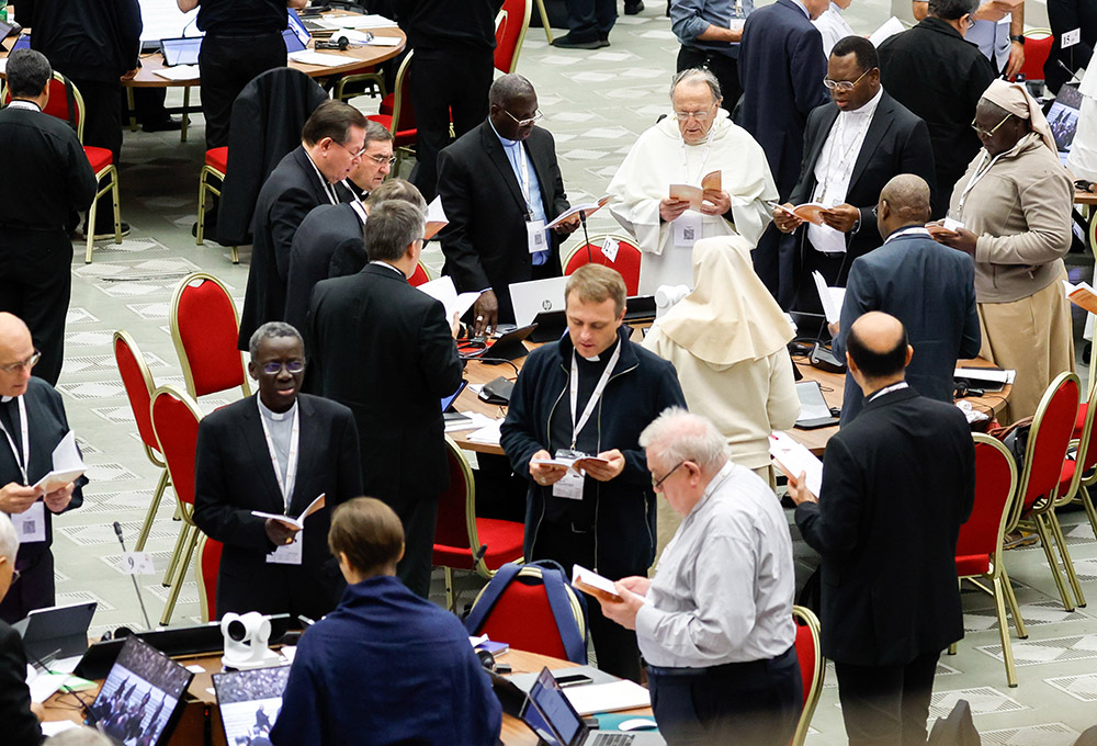 Miembros de la asamblea del Sínodo de los Obispos rezan el 26 de octubre antes de una sesión de trabajo en el Aula de Audiencias Pablo VI del Vaticano. (Foto:CNS/Lola Gómez)