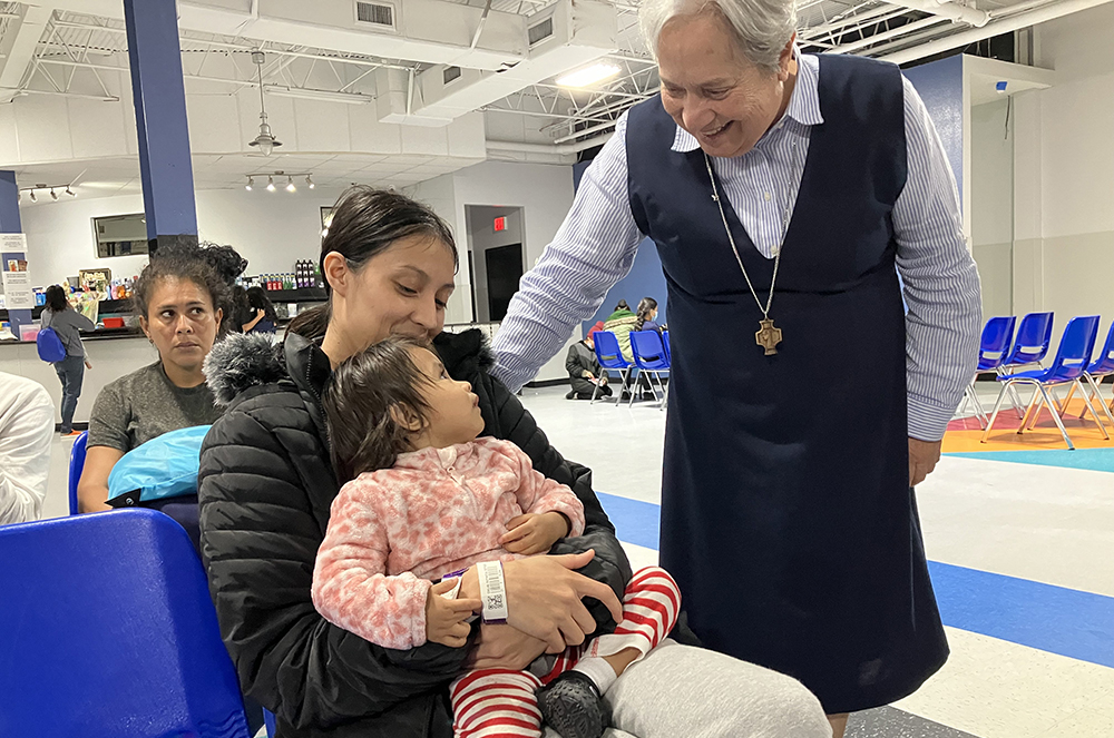 Sr. Norma Pimentel, a Missionary of Jesus, greets Esther Chicas, a recently arrived migrant from El Salvador, and her child, Andrea, at the Humanitarian Respite Center in McAllen, Texas on Nov. 11. Pimentel has urged Catholics to "defend life" through projects such as Catholic Charities' work with the migrant population, especially at the border. (OSV News/David Agren)