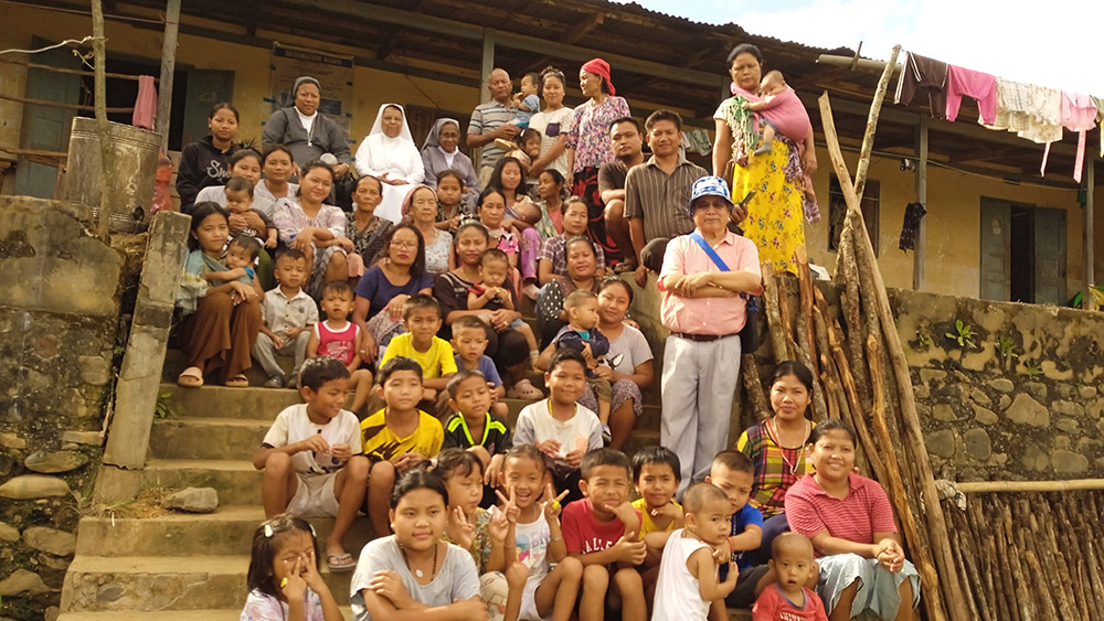 Salesian sisters with children residing in a temporary relief camp at Churachandpur in Manipur, where Homes of Hope distributed relief materials. In the back row, starting second from left, are Srs. Annie Inchenat, Maria Dilbung and Tresa Karot. (Courtesy of Tresa Karottukunnel)