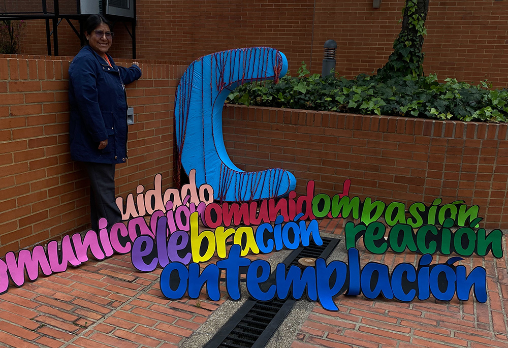 Una mujer posa con un despliegue de siete palabras que comienzan con la letra c en el campus de la Universidad de La Salle en Bogotá, Colombia, el 24 de noviembre de 2023.