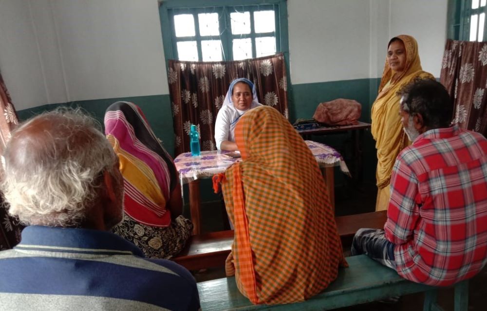 A nun sits in front of a group of people and talks.