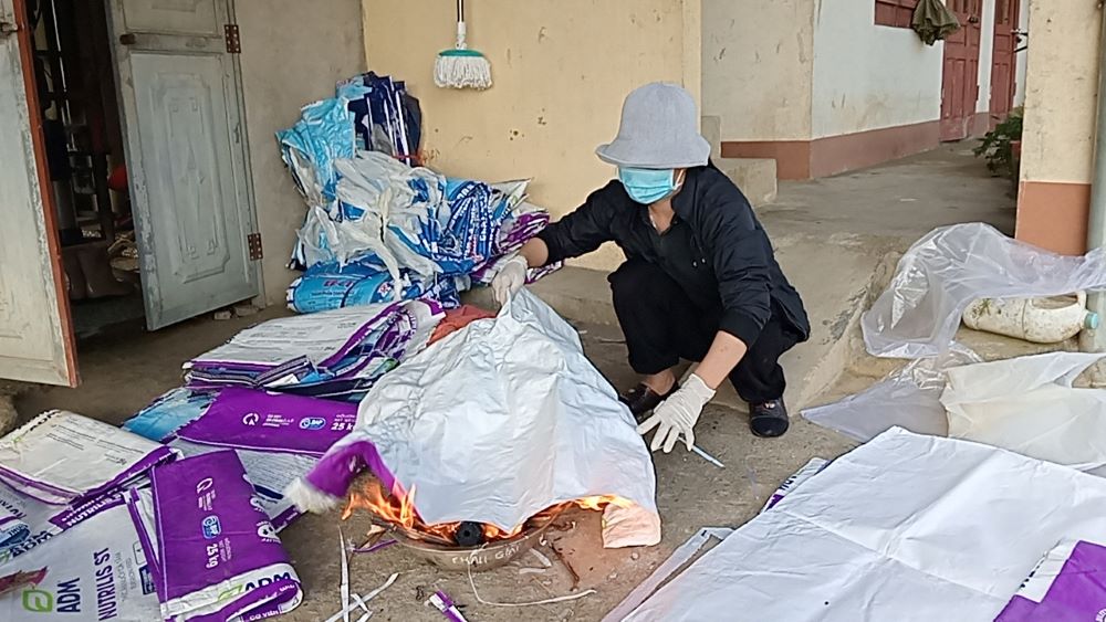 Lovers of the Holy Cross of Hung Hoa Sr. Mary Hoang Thi Phuong wears  a hat and mask to avoid toxic fumes from plastic bags on Dec. 13. 