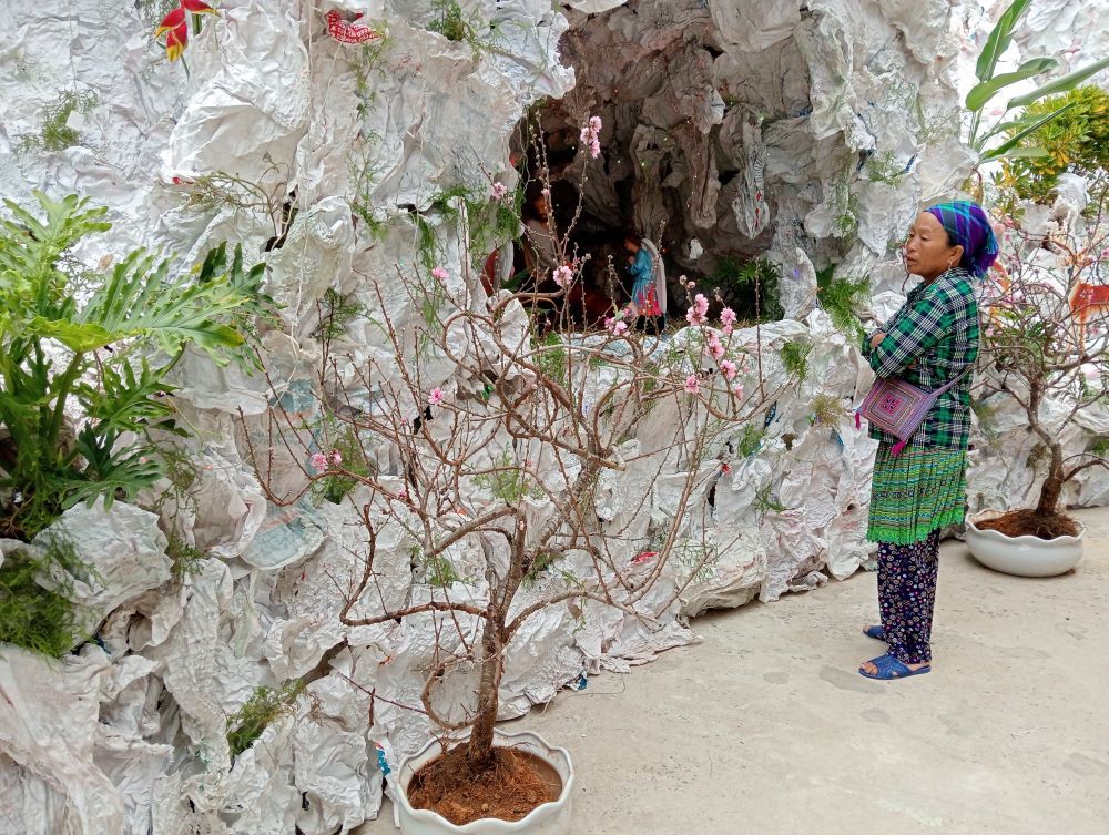 Hmong Teresa Ly Thi Xua, 40, prays before a Christmas nativity made with leaves, bamboo, paper and flowers in the compound of Pho Lu Church in Lao Cai province.