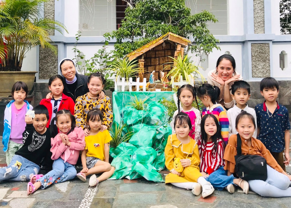 Daughters of Our Lady of the Visitation Sr. Mary Truong Thi Danh (left), a teacher and children pose for a photo at Phu Vang convent on Dec. 9 