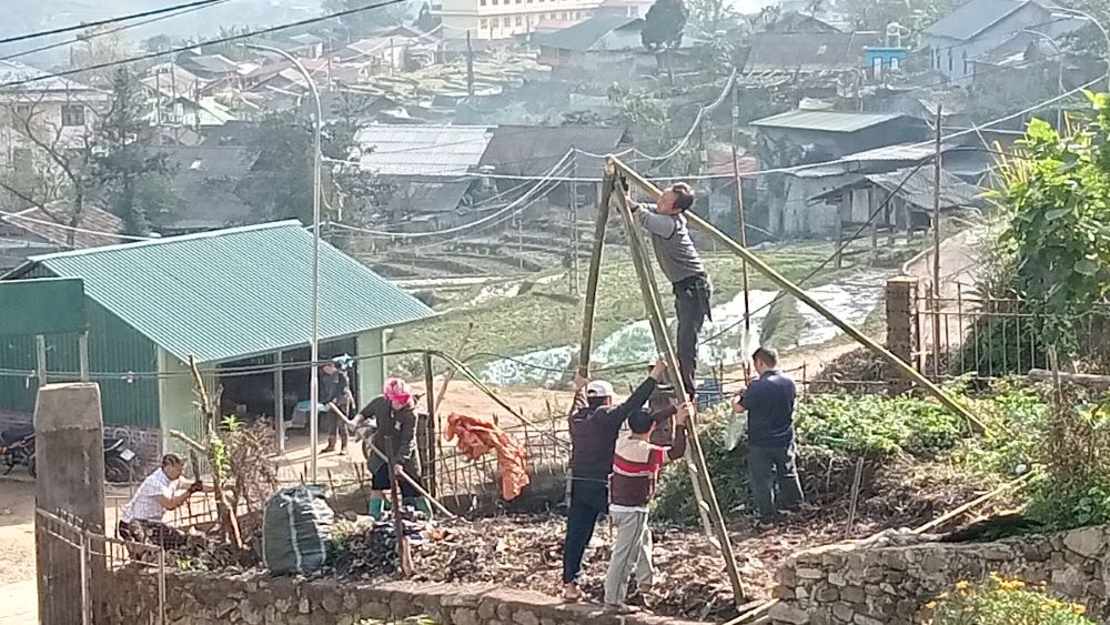 Hmong Catholics clear a site and use bamboo, leaves and straw to build a crèche in front of Lao Chai Church on Dec. 15. (Joachim Pham)