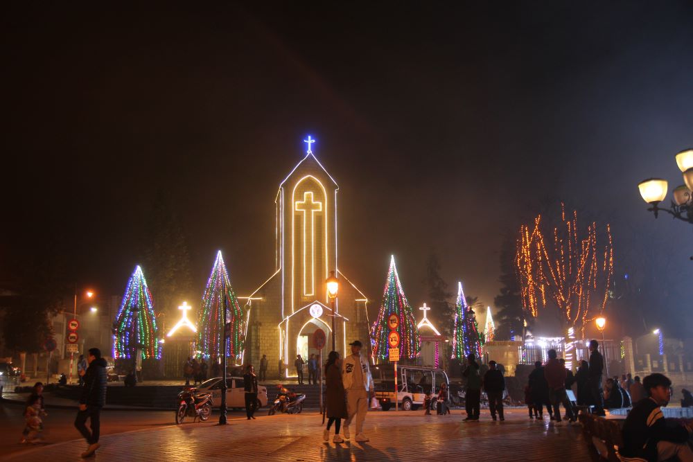 Tourists and locals gather at night to admire Sa Pa Church, decorated with colorful lights, Christmas trees and nativities. The stone church is a famous tourist destination in Sa Pa town. (Joachim Pham)