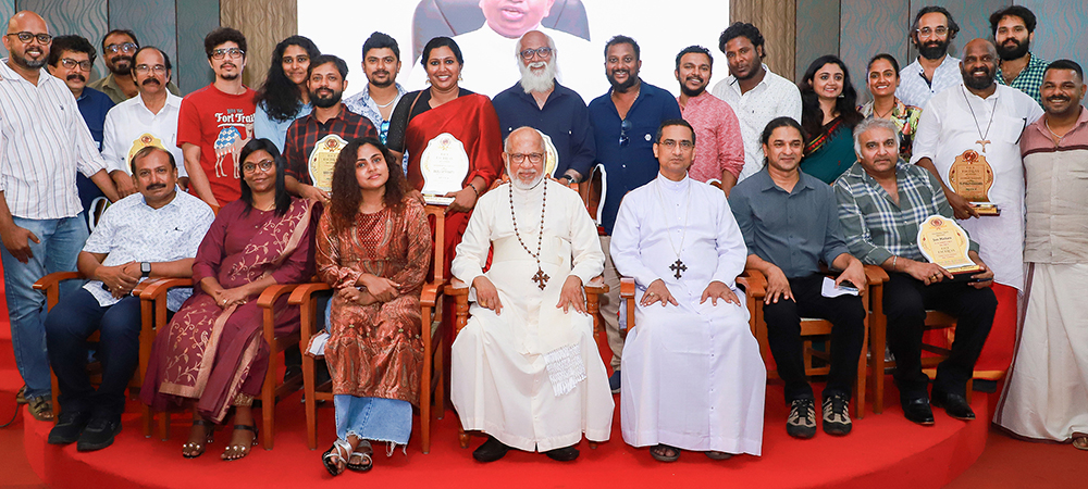 Cardinal George Alencherry, sitting center, is pictured with the crew of "The Face of the Faceless," including Vincy Aloshious, to the left of the cardinal, who plays the role of Sr. Rani Maria; director Shaison P. Ouseph (sitting, second from right); producer Sandra D'Souza Rana (sitting, second from left); and Fr. Stanley Kozhichira (row behind the cardinal, second from right) who plays the role of a villain in the movie. (Courtesy of Shaison P. Ouseph)
