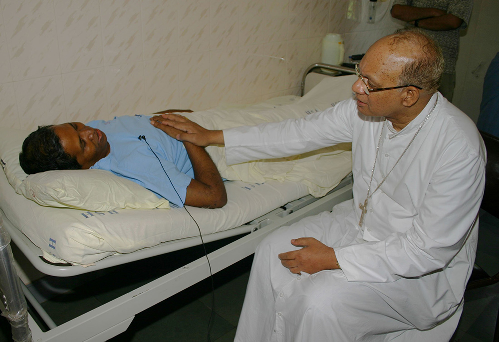 Cardinal Oswald Gracias of Mumbai, India, consoles Fr. Bernard Digal at Mumbai's Holy Family Hospital Sept. 6, 2008. Digal was severely beaten by Hindu extremists and left to die in the Kandhamal jungles Aug. 26, 2008, during anti-Christian violence. (CNS/Anto Akkara) 