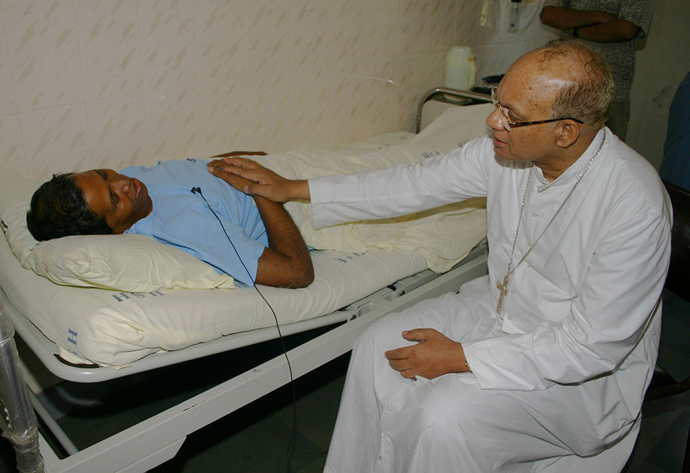 Cardinal Oswald Gracias of Mumbai, India, consoles Fr. Bernard Digal at Mumbai's Holy Family Hospital Sept. 6, 2008. Digal was severely beaten by Hindu extremists and left to die in the Kandhamal jungles Aug. 26, 2008, during anti-Christian violence. (CNS/Anto Akkara)