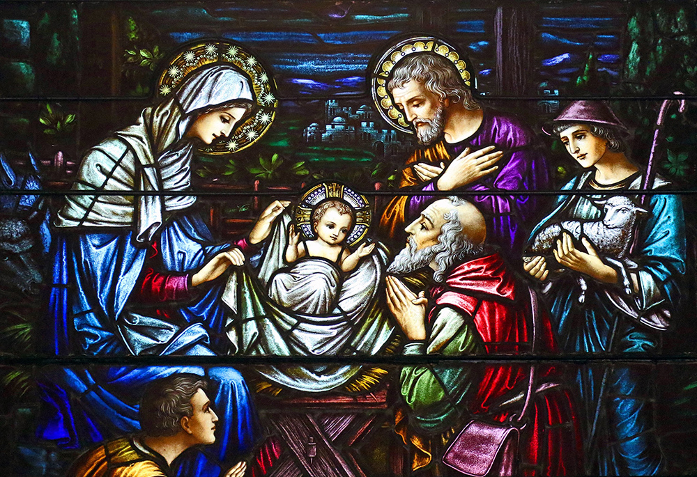 This stained glass window at St. Aloysius Church in Great Neck, New York, depicts Jesus in a manger, surrounded by Mary, Joseph and three shepherds. The feast of the Nativity of the Lord is celebrated Dec. 25. (OSV News/Gregory A. Shemitz)