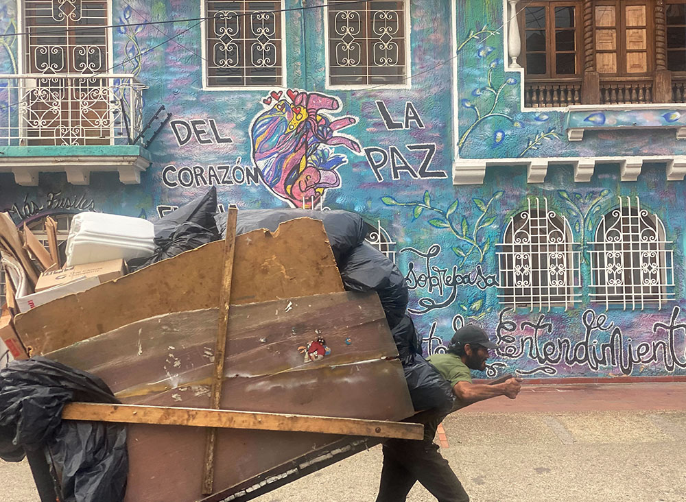 A man pulls a cart of recycled material past a mural that says "From the heart comes peace" in Bogotá, Colombia, Nov. 22. Though 2016 peace accords put an end to the decadeslong conflict between the Revolutionary Armed Forces of Colombia (FARC) and the government, Colombia's poorest, many in rural communities, still suffer violence, said Dominican Sr. Diana Herrera Castañeda. (GSR photo/Rhina Guidos)