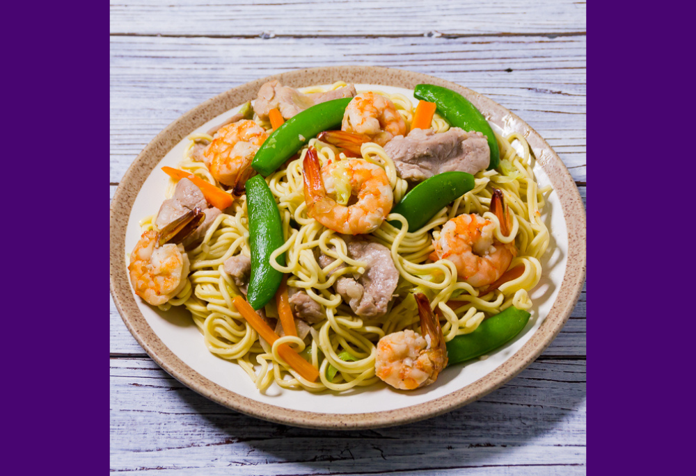 A plate of pancit canton is pictured. On special days like Christmas, pancit was a favorite holiday dish that Terri Laureta's aunt would make, a savory combination of egg noodles, rice noodles, meat and vegetables. (Flickr/Joost Nusselder, BiteMyBun.com, CC BY 2.0 Deed)