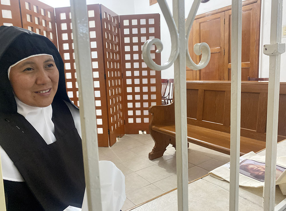 Behind the grille at the 130-year-old St. Joseph of Guadalupe Monastery, Discalced Carmelite Sister Dora Patricia del Jesús Resucitado explains a bit about its history Aug. 27 near the grounds of the Our Lady of Guadalupe Basilica in Mexico City. (GSR photo/Rhina Guidos)