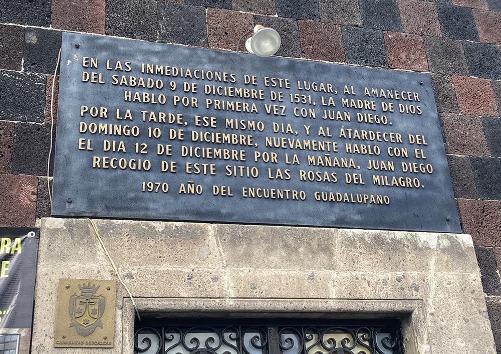 A plaque above the door of the St. Joseph of Guadalupe Monastery near the grounds of Mexico City's Basilica of Our Lady of Guadalupe says near that spot "at dawn on Dec. 9, 1531, the mother of God appeared for the first time to Juan Diego," referring to the Indigenous Mexican saint, said to have been witness to 16th-century apparitions of Mary in the surroundings of Tepeyac Hill. (GSR photo/Rhina Guidos) 