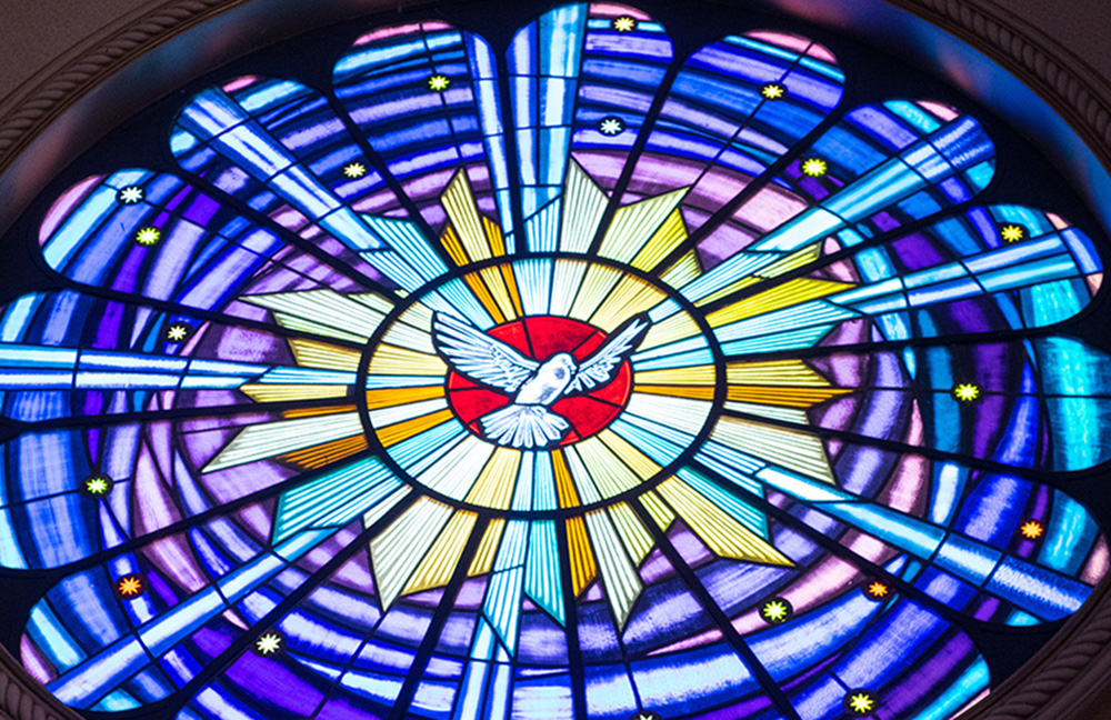 A dove representing the Holy Spirit in a stained glass window (Unsplash/Mateus Campos Felipe)