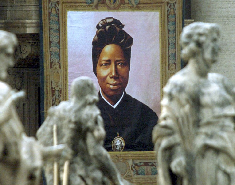 An image of St. Josephine Bakhita, a former Sudanese slave who became a nun, hangs from the facade of St. Peter's Basilica Oct. 1, 2000. 