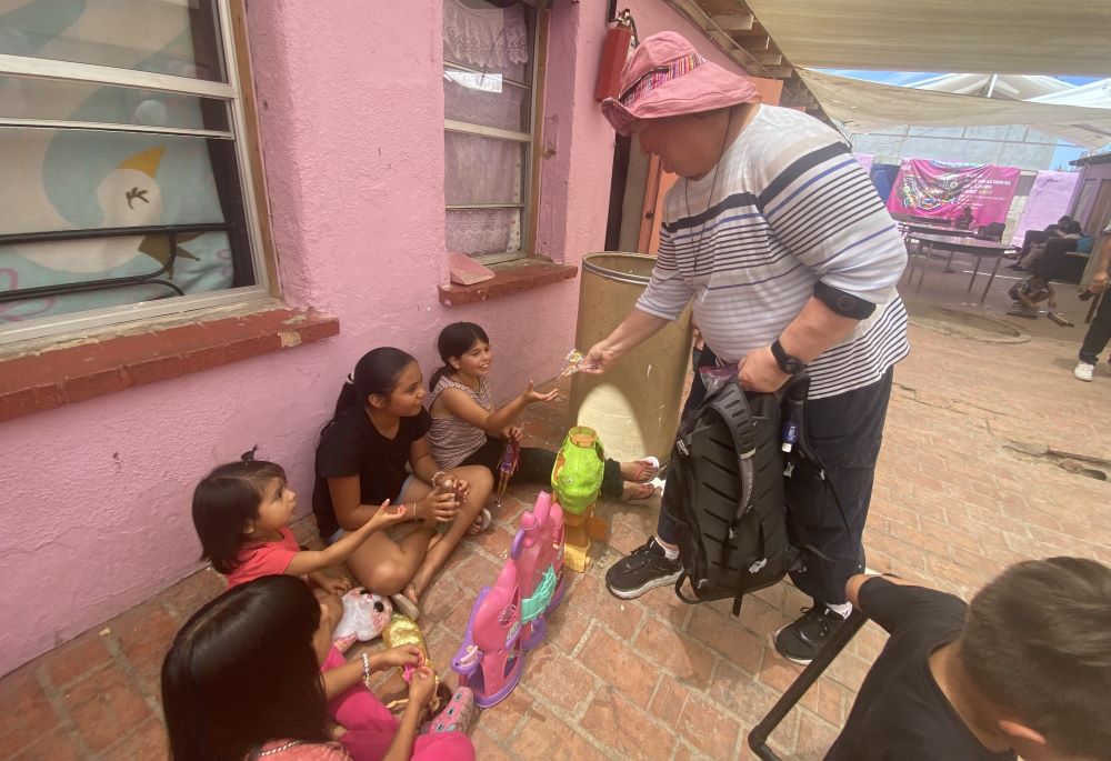 La Hna. Lisa Buscher, de la Sociedad del Sagrado Corazón, comparte dulces con niños en un albergue para migrantes en Mexicali, México, el 9 de mayo de 2023. La religiosa, que trabaja con migrantes y refugiados en San Diego y comunidades fronterizas cercanas, insta a tener una visión compasiva para con ellos. (Foto: GSR/Rhina Guidos) 