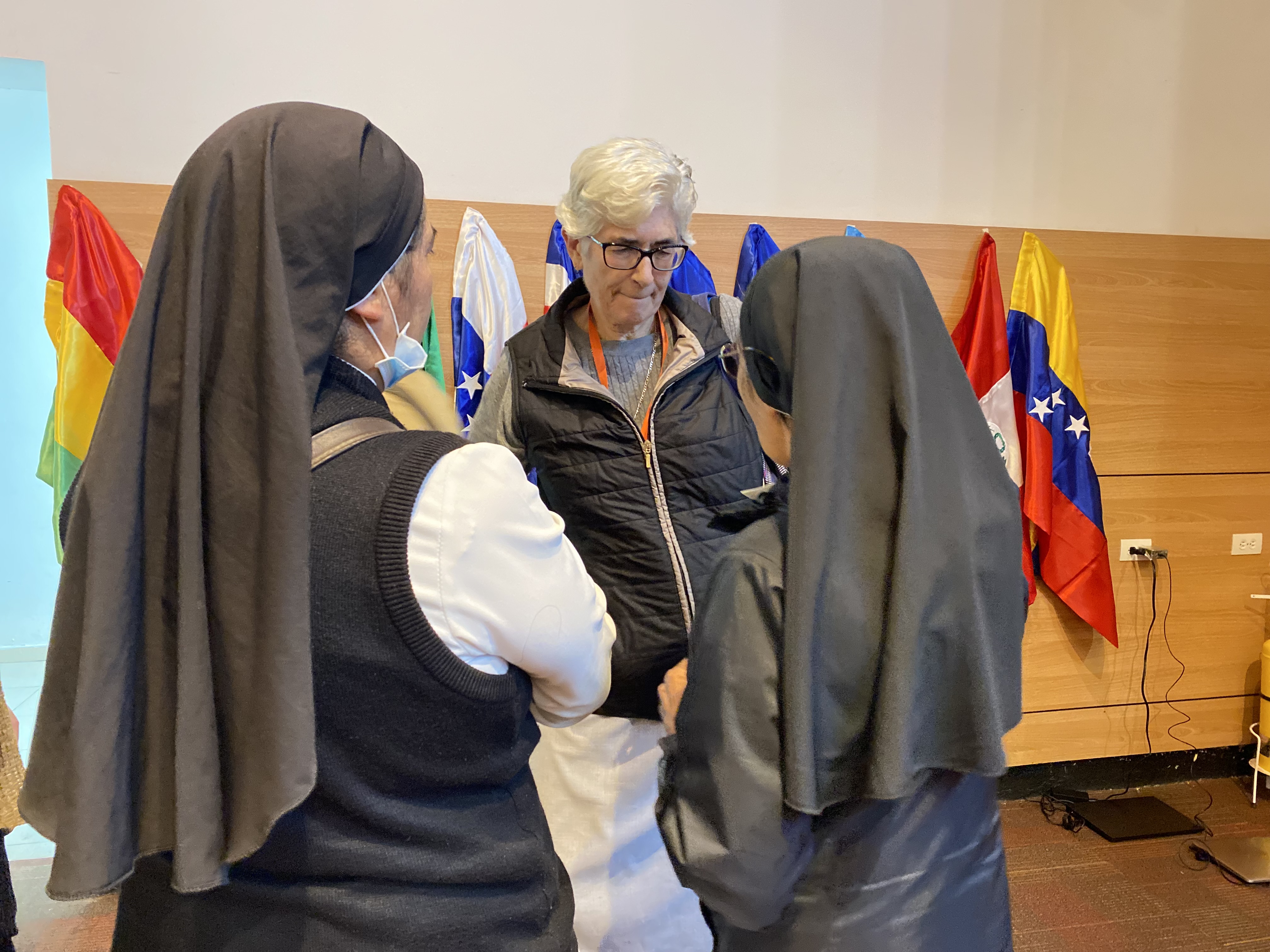 Sr. Maria de los Dolores Palencia Gómez, of the Sisters of St. Joseph of Lyon, who works with migrants in Mexico, stops to chat with two sisters in Bogotá, Colombia, Nov. 24.