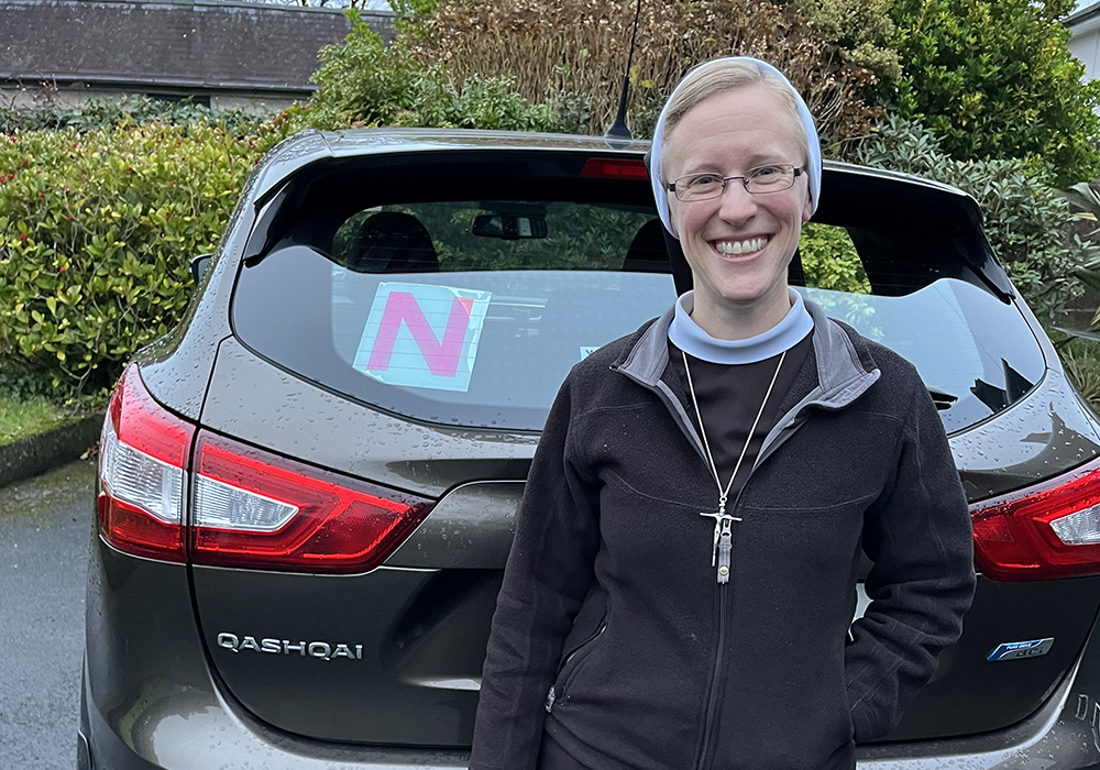 Sr. Kathryn Press poses with N plates on her car (N for novice driver). After moving to Ireland and passing a driving test, Press had to keep the plates on her car for two more years. (Courtesy of Kathryn Press)