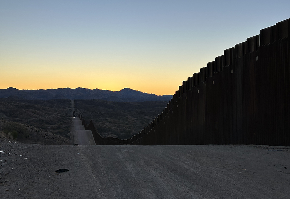 The sun rises above the horizon along the U.S.-Mexico border wall. (Peter Tran) 