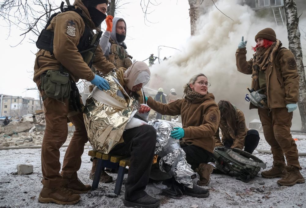 Emergency personnel treat a wounded resident of an apartment building in Kharkiv, Ukraine, that was heavily damaged in a Russian missile attack on Jan. 23. 