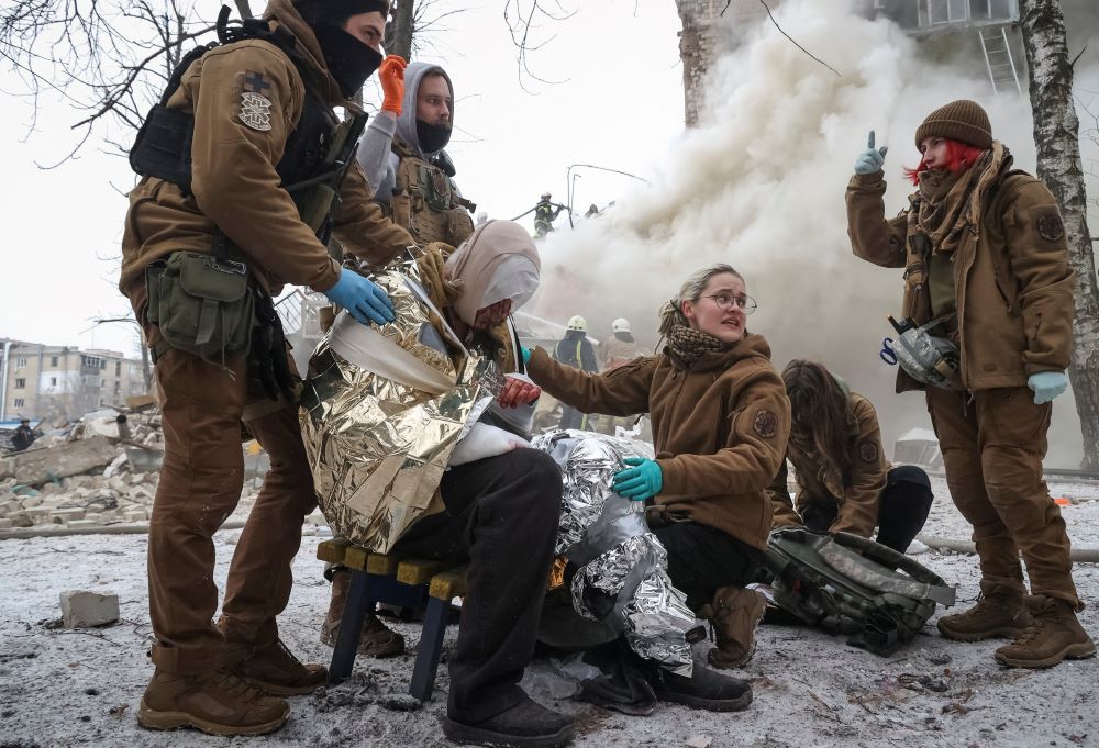 Emergency personnel treat a wounded resident of an apartment building in Kharkiv, Ukraine, that was heavily damaged in a Russian missile attack on Jan. 23.