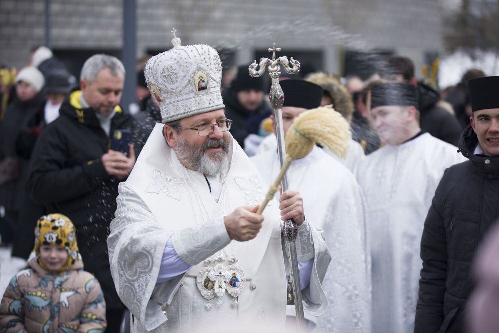 Major Archbishop Sviatoslav Shevchuk, head of the Ukrainian Greek Catholic Church, sprinkles worshippers with water during the blessing of water on the Dnipro River after he celebrated a Divine Liturgy Jan. 6 at the Patriarchal Cathedral of the Resurrection of Christ in Kyiv.