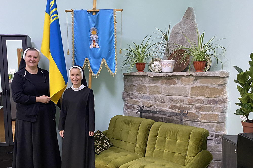 Sr. Yeronima Rybakova, left, holds part of a Ukrainian flag next to Sr. Josifa Lesnichenko, who teaches English at the school that the Sisters of the Order of St. Basil the Great operate in Ivano-Frankivsk, Ukraine, Sept. 3, 2022. (CNS/Rhina Guidos)
