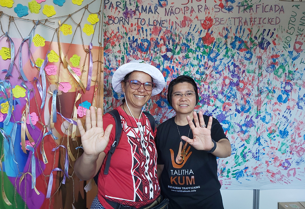 Sr. Abby Avelino (right) celebrates World Youth Day 2023 with a Talitha Kum member from Brazil. Talitha Kum’s booth featured painted hands to advocate for the prevention of human trafficking. Avelino said her team met with hundreds of young people who participated in raising awareness against human trafficking. (Courtesy of Abby Avelino)