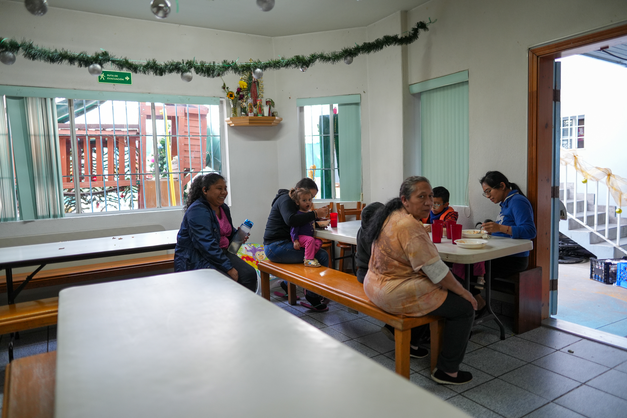 Un grupo de mujeres migrantes se reúne para compartir un momento de respiro y apoyo mutuo. En el Instituto Madre Asunta reciben alimentos mientras dure su permanencia en el albergue y también para que lleven en su viaje. (Foto: Jorge Nieto)