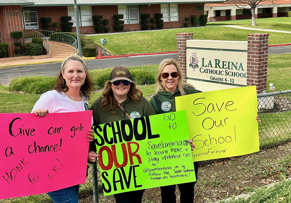 Participants in a protest display signs outside the grounds of La Reina, a high school and middle school run by the Sisters of Notre Dame in Thousand Oaks, California. The protest was organized by the group Save La Reina to prevent the closure of La Reina. (Tom Hoffarth)