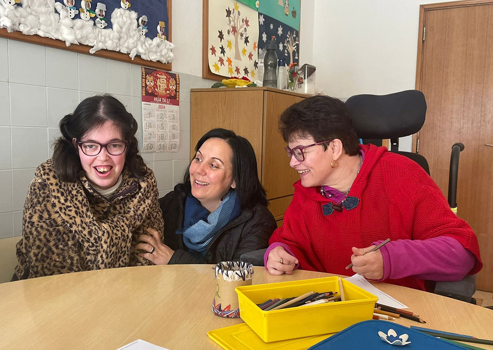 Sr. Ana da Paz Nunes (center), of the Franciscan Sisters of Divine Providence, interacts with two residents of the House of the Good Samaritan in Fátima, Portugal. One of the daily activities at the house is painting and drawing. (GSR photo/Leopoldina Reis Simões)