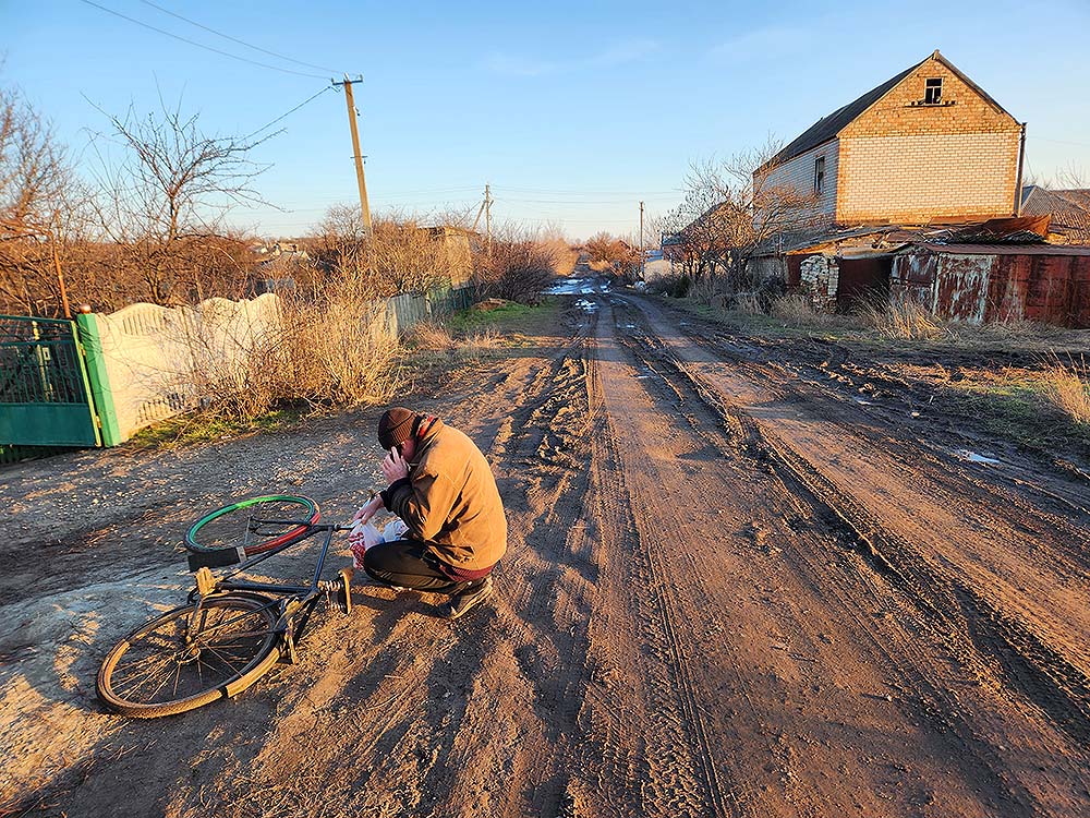 Un hombre prepara su bicicleta en el pueblo de Orihiv tras la entrega de artículos humanitarios por parte de un grupo de hermanas visitantes de la congregación de San Basilio el Grande a principios de este mes. (Foto: GSR /Chris Herlinger)