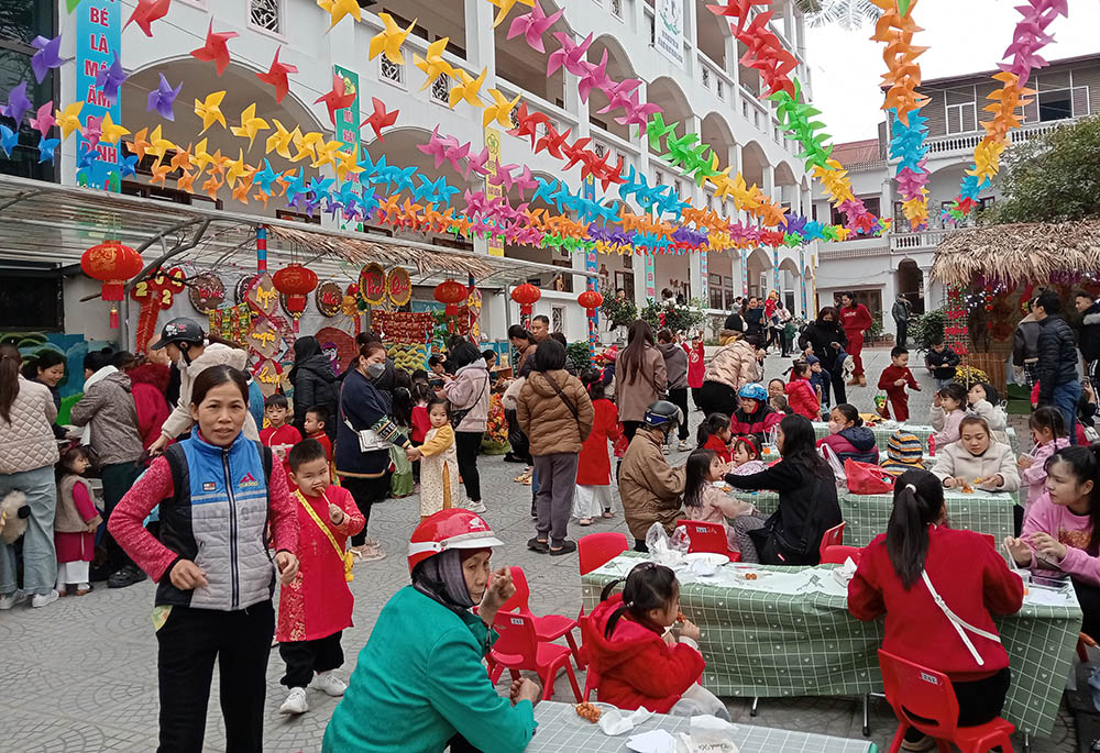 Parents and their children enjoy traditional food, buy vegetables, play folk games and watch a cultural performance by Lovers of the Holy Cross of Hung Hoa nuns on Jan. 29 at a day care center in Yen Bai City, Vietnam. (Joachim Pham)