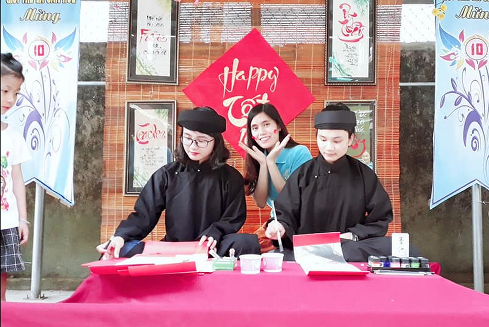 Daughters of Mary of the Immaculate Srs. Mary Rose of Lima Cao Thi Bich (left) and Anne Truong Thi Mai Khoi (both in black costume) perform calligraphy and give to single mothers and their children at Anh Bang convent in Thua Thien Hue province on Jan. 31. (Joachim Pham)