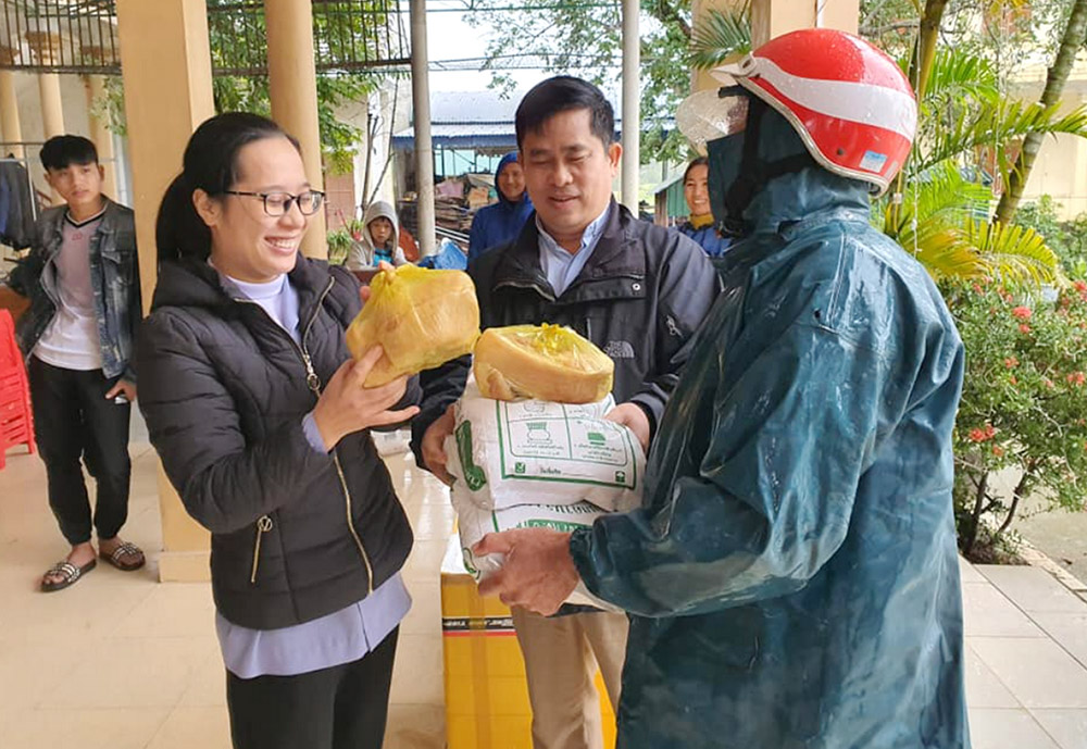 Lovers of the Holy Cross of Hue Sr. Maria Huynh Thi Dieu gives pork and rice to a farmer in Thua Thien Hue province on Feb. 3. Dieu said the nuns provide food to 50 families who had their crops and poultry washed away by floods last November. (Joachim Pham)