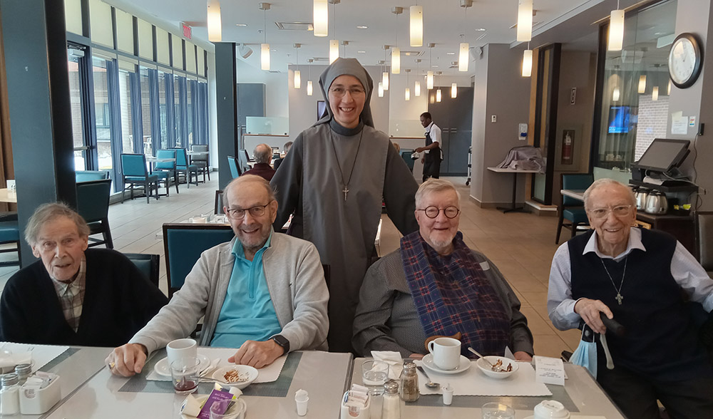 La hermana Natalia Vázquez, de Mater Dei, se une a los sacerdotes mayores durante el almuerzo en la residencia Angus en Montreal. (Foto: cortesía de Natalia Vázquez)