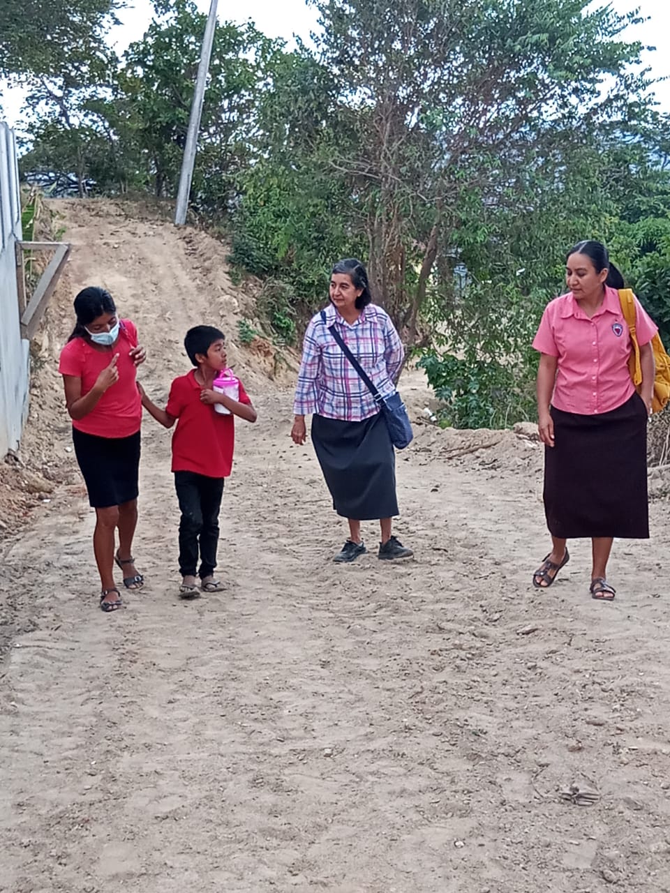 Las hermanas Misioneras de la Eucaristía Alicia Guevara Pérez (al centro) y Verónica Tenorio González caminan en 2021 junto con una familia hacia la comunidad El Zapote para visitar a los enfermos. (Foto: cortesía Hna. Alicia Guevara P.)