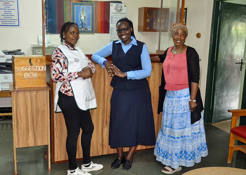 Daughter of Charity Sr. Susan Tanui, with Grace Khasandi and Margaret Nekesa, staff members at the DREAM Center, Lang'ata, Nairobi, Kenya. Every day, mentors from the center make calls to clients who need reminders to take their medication and attend appointments. (Lourine Oluoch)