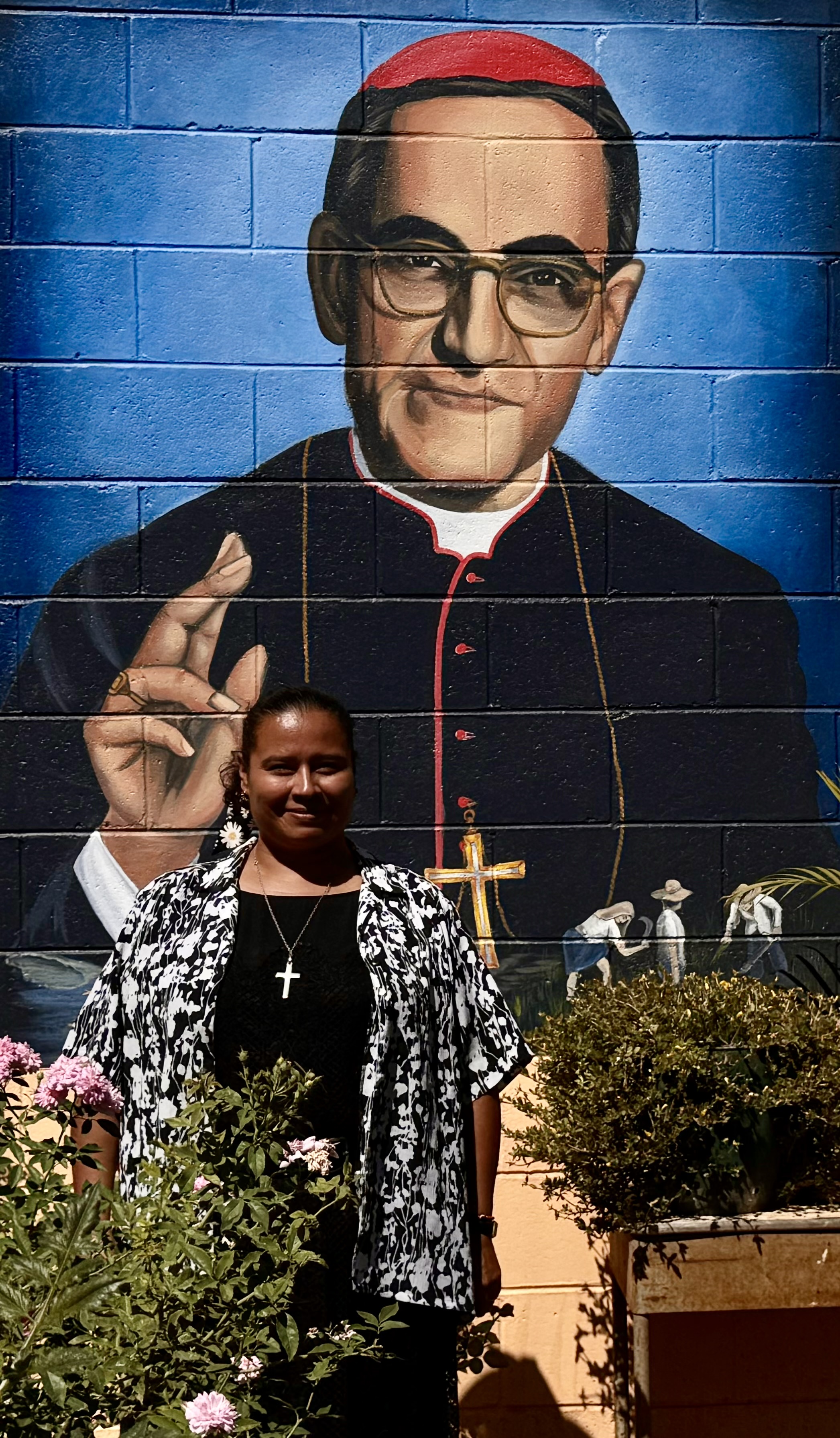 Notre Dame Sr. Sandra Margarita Sierra Flores poses for a photo in front of a mural of St. Oscar Romero on Jan. 27, 2024, in Chalatenango, El Salvador. She said she is inspired by the life of the saint, his writings and his devotion to the poor, which has influenced her ministry. (GSR photo/Rhina Guidos) 